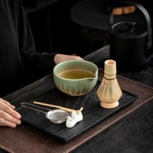 Japanese style matcha tea set with ceramic bowl, bamboo whisk, sifter, and scoop in gift packaging.